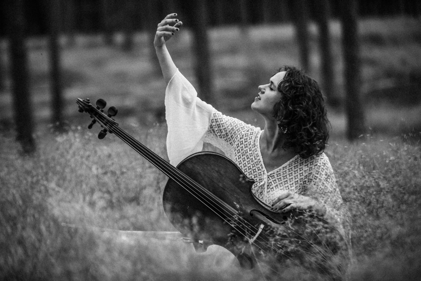 Elena Daunytė su violončele pievoje