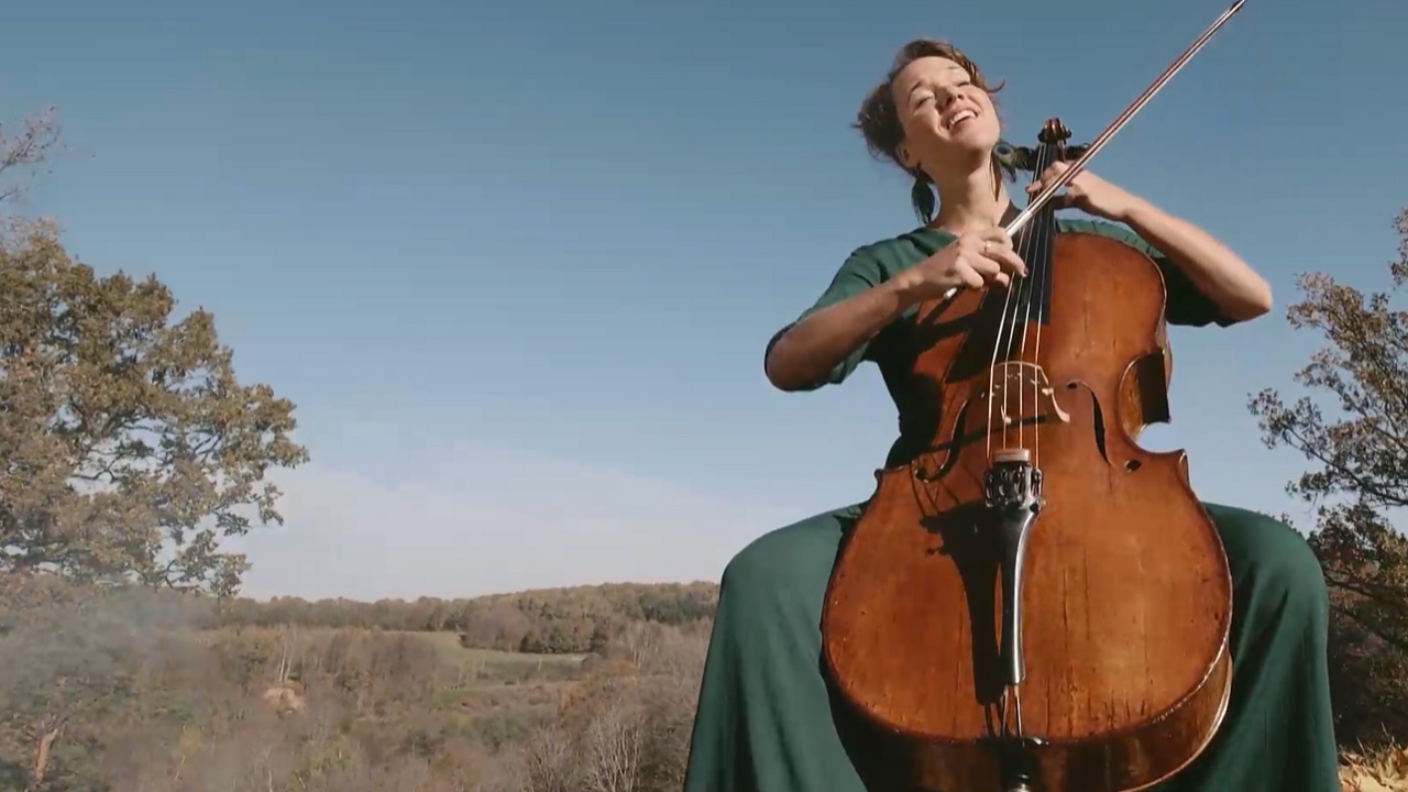 Elena Daunytė groja violončele gamtoje — kadras iš klipo „Ryto ugnis“
